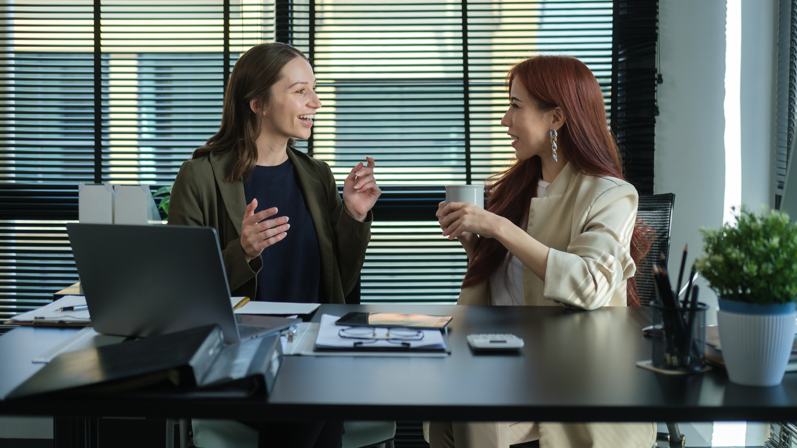 two women co-workers happily having a conversation